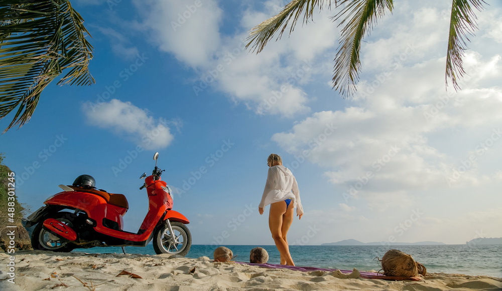 Scooter road trip. Woman alone on red motorbike in white clothes on sand beach by ocean. One girl caucasian tourist walk near tropical palm tree, sea. Asia Thailand Motorcycle rent. Safety helmet.