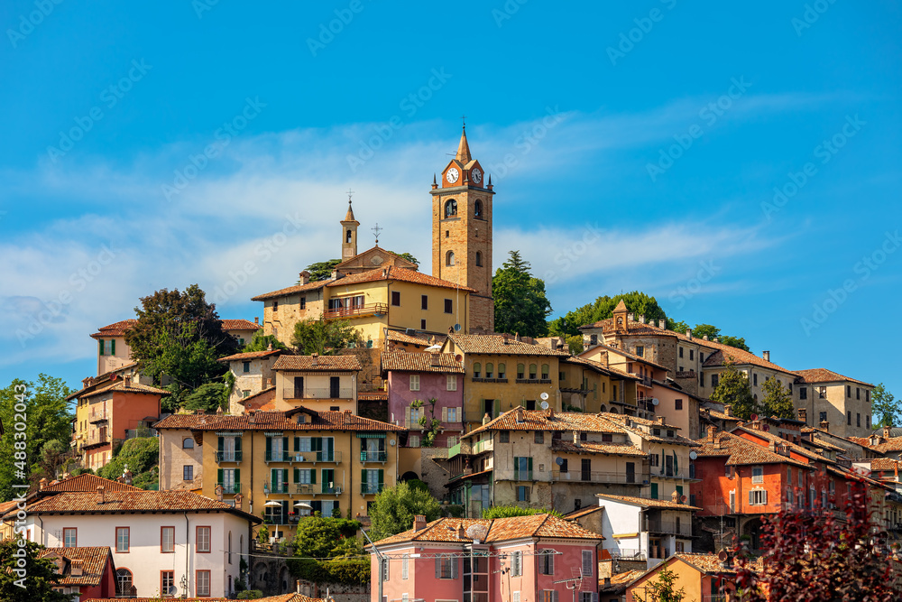 Small town of Monforte d'Alba under blue sky in Italy.