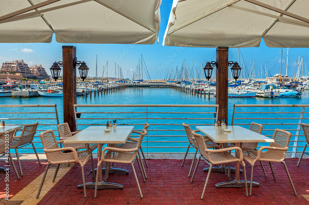 Fototapeta premium Outdoor restaurant and marina on background in Ashqelon, Israel.