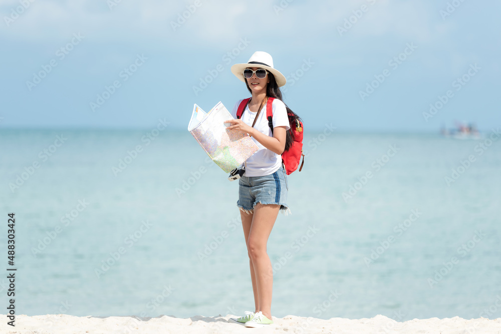 Happy traveler and tourism young women travel summer on the beach.  Asian smiling people holding map and camera take photo  and relax outdoor for destination and leisure trip travel in holiday