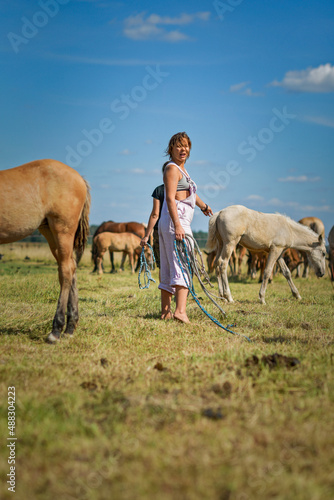 A young beautiful girl works on a horse farm. © shymar27