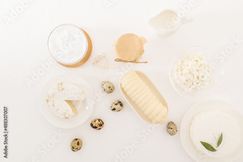 an assortment of dairy products on a white table. sour cream, cheese, cottage cheese, milk, yogurt. milk den. dairy diet. top view.flat lay.