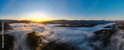 Aerial panoramic view of sunrise above the clouds in the Mountains of the Alps