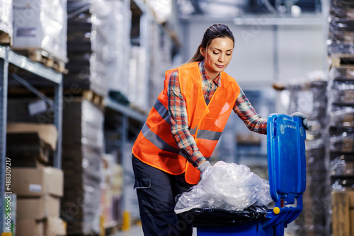 A storage worker putting garbage into a recycle bin. photo