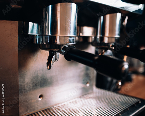 Details of a modern chrome coffee machine in the dim light of a coffee shop - professional barista equipment