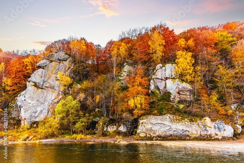 Rocky cliff with yellowed trees and mountain river in autumn © YouraPechkin