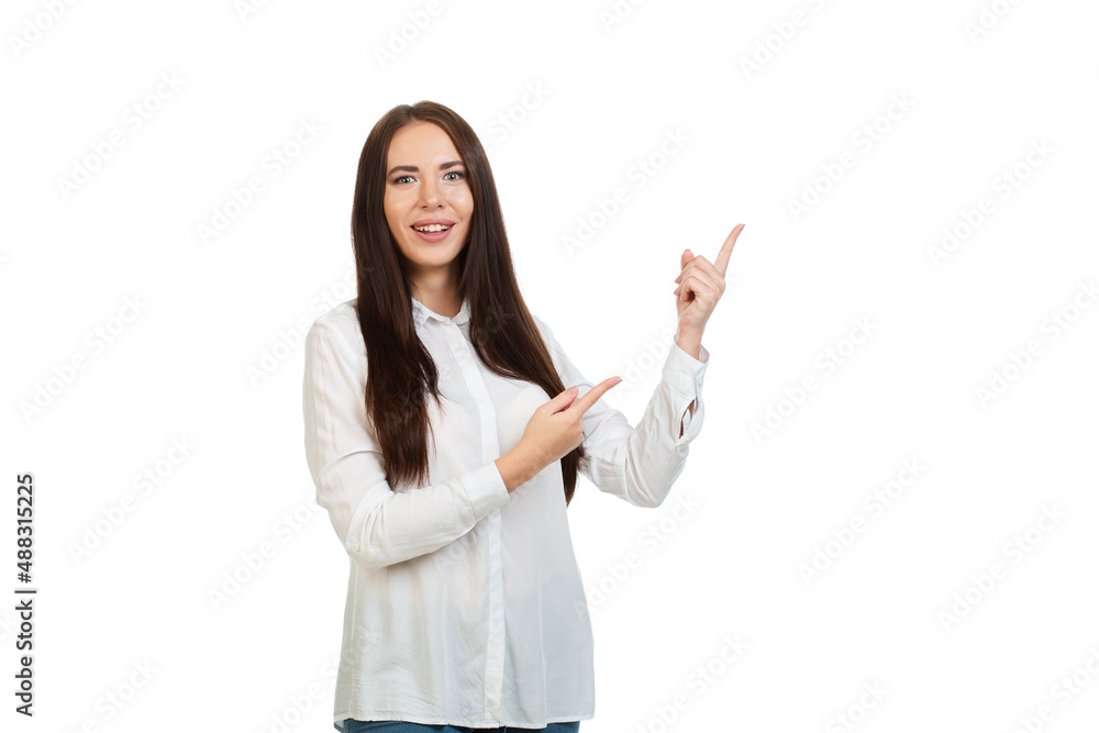 Young, beautiful calm girl isolated on a white background in a white shirt, points his fingers at the place for promotions, offers or advertising. Young, beautiful calm girl isolated on a white background in a white shirt, points his fingers at the place for promotions, offers or advertising.