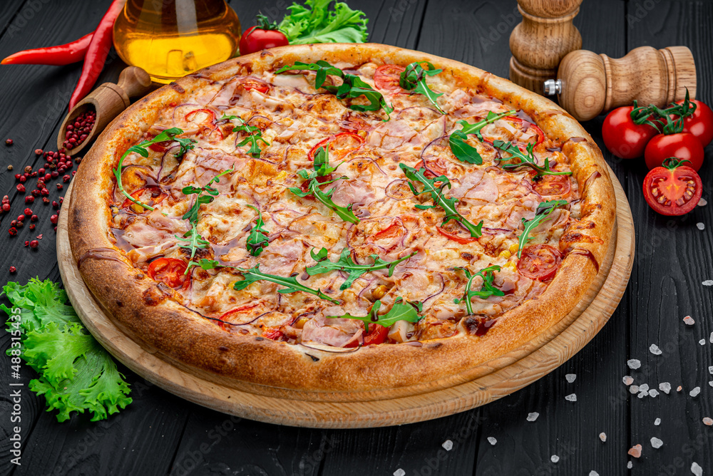 Delicious Italian pizza with sausage, ham and vegetables