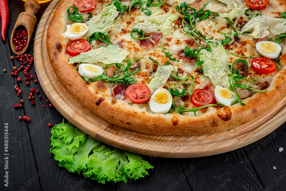 Pizza Caesar on board on wooden table
