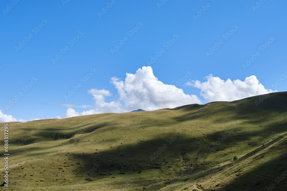 beautiful green hill with a blue sky covered with white clouds in Col de Peyresourde, France beautiful green hill with a blue sky covered with white clouds in Col de Peyresourde, France