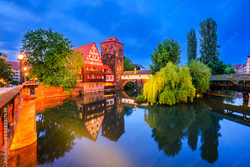 Fototapeta premium Nuremberg, Germany. The Wine Warehouse (Weinstadel) and Hangman's Bridge (Henkersteg) at night.