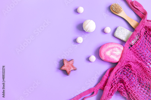 Spa composition with bath accessories in a pink string bag, flat lay. © puhimec
