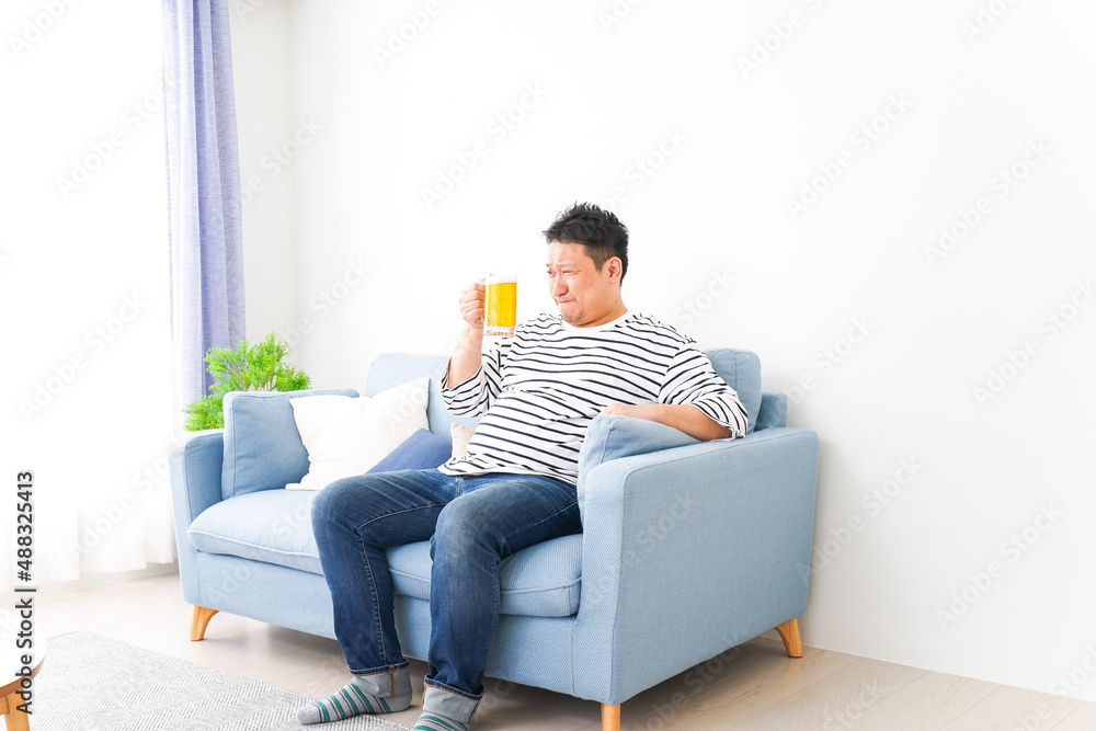自宅でビールを飲む中年の男性