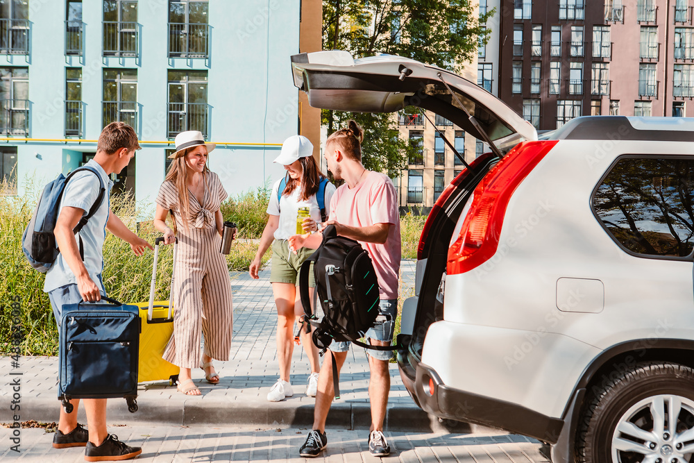 Obraz premium friends load car trunk with baggage