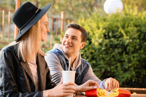 Young couple eating french ...