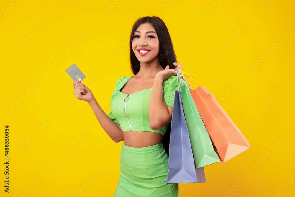 Happy lady holding credit card carrying shopping bags Happy lady holding credit card carrying shopping bags