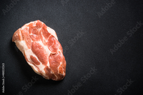Raw meat. Fresh steak, pork steak at black background. Top view with copy space.