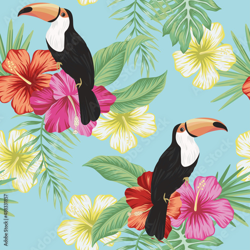 Tropical vintage toucan bird, red magenta yellow hibiscus flower, palm leaves floral seamless pattern blue background. Exotic jungle wallpaper.