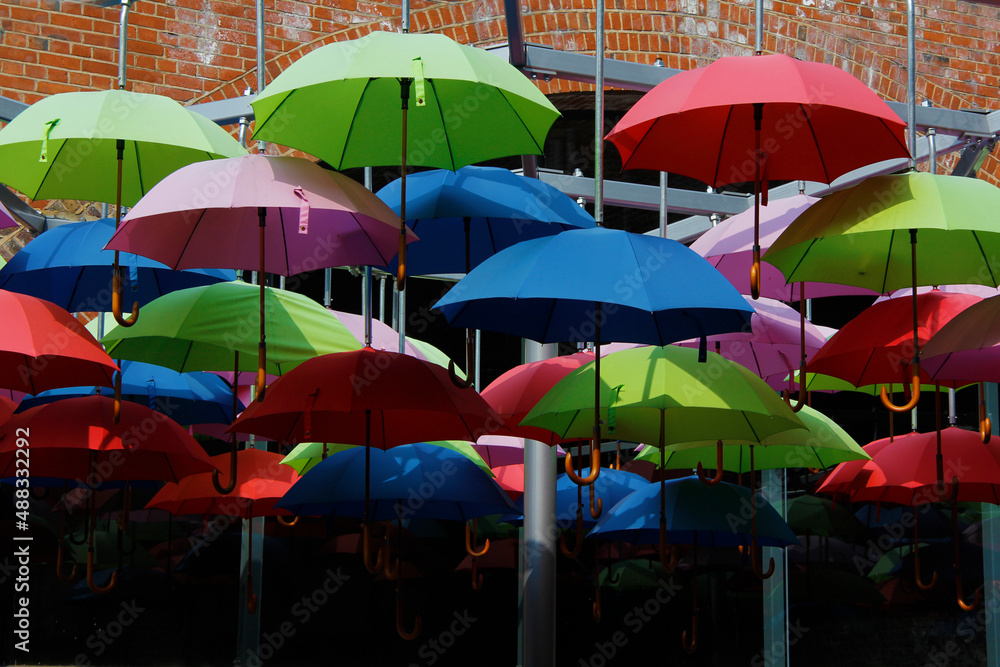 many colourful hanging umbrellas in artist arrangement giving shade from the sun