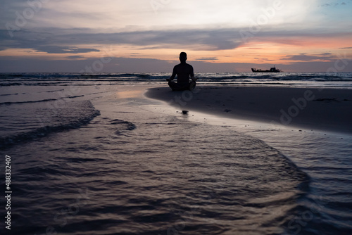 Silhouette of Man Meditate on Beach at Sunset