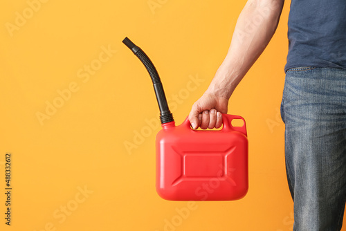 Man holding canister with rubber nozzle on color background photo