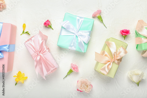 Beautiful spring composition with flowers and gift boxes on light background © Pixel-Shot