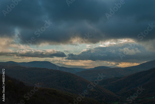 Mountainous landscape with a cloudy sunset sky © Simn