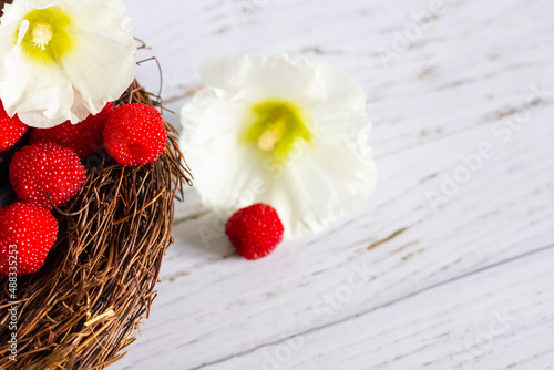 Fresh berries of Tibetan raspberries in a basket on a wooden background.