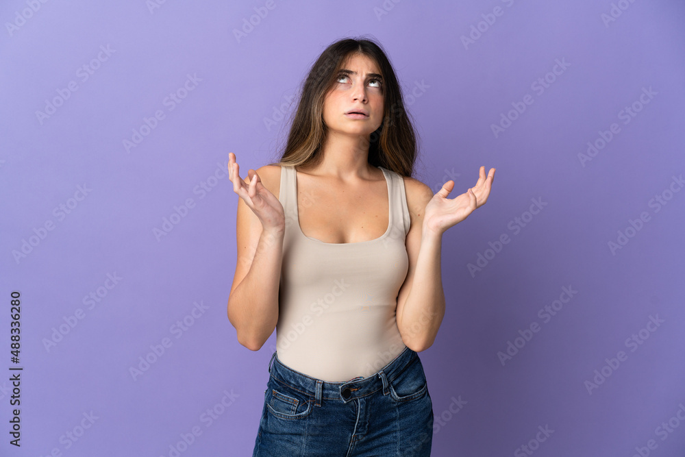 Fototapeta premium Young caucasian woman isolated on purple background stressed overwhelmed