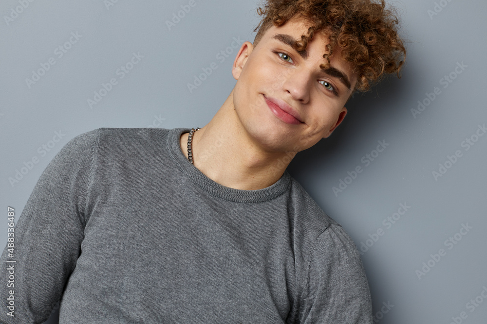 Obraz premium stylish guy in a gray sweatshirt fashion studio isolated background