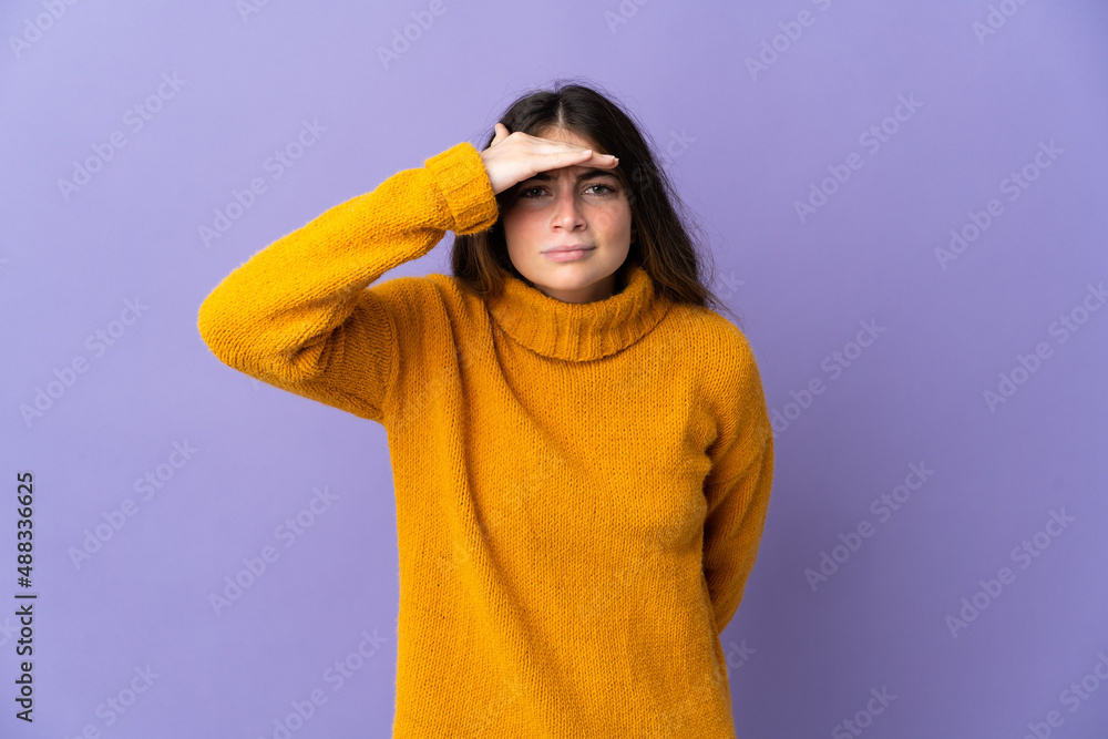 Young caucasian woman isolated on purple background looking far away with hand to look something Young caucasian woman isolated on purple background looking far away with hand to look something
