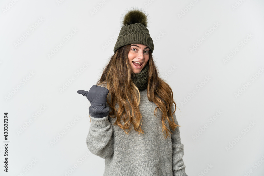 Young caucasian woman with winter hat isolated on white background pointing to the side to present a product Young caucasian woman with winter hat isolated on white background pointing to the side to present a product