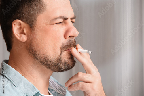 Handsome smoking man at home