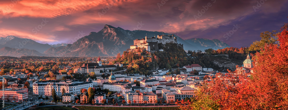 Fototapeta premium Colorful evening cityscape. Panoramic view on historic city of Salzburg with famous Hohensalzburg Fortress. Wonderful autumn landscape with picturesque sky. Softlight effect. Salzburger Land, Austria