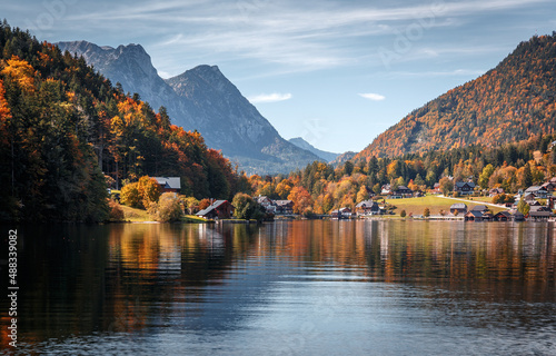 Scenic panorama of beautiful alpine autumn view with lake, mountains, green meadow and perfect sky. Amazing nature scenery. Wonderful sunny landscape. Grundlsee. Austria