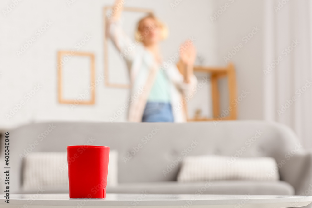 Modern wireless portable speaker on table in room Modern wireless portable speaker on table in room