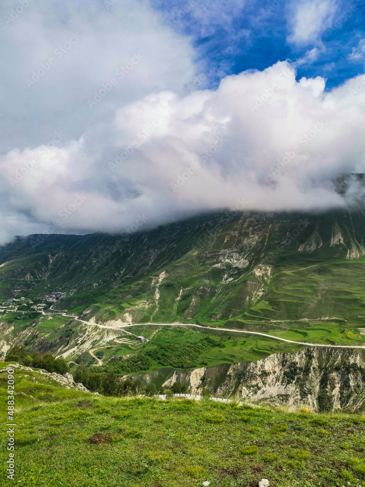 A road in the mountains of Dagestan with large mountains in the background and clouds. Russia.