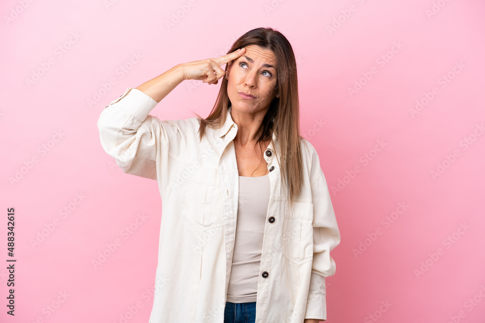 Middle age caucasian woman isolated on pink background with problems making suicide gesture Middle age caucasian woman isolated on pink background with problems making suicide gesture