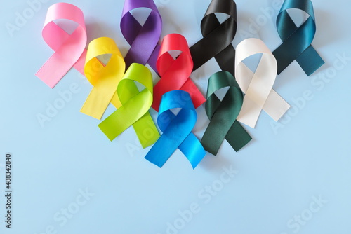 Obraz na płótnie Set of colorful cancer awareness ribbons flat lay in blue background. World Cancer Day concept. w salonie