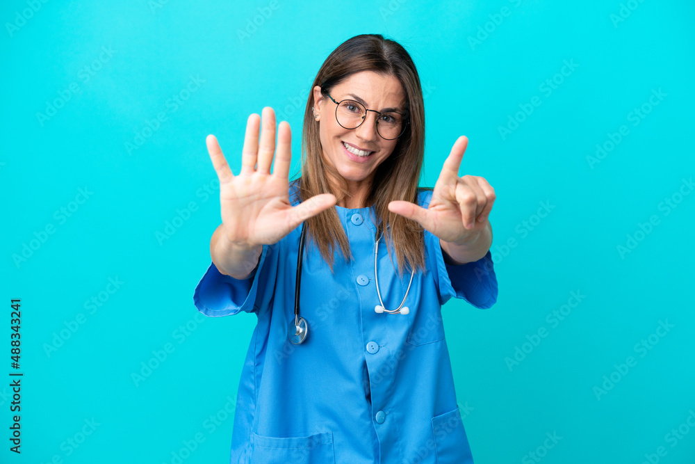Middle age surgeon woman isolated on blue background counting seven with fingers Middle age surgeon woman isolated on blue background counting seven with fingers