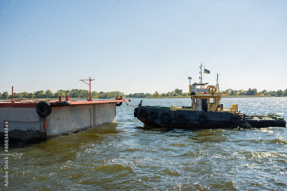 A tugboat pulls a floating concrete pontoon. A tugboat pulls a floating concrete pontoon.