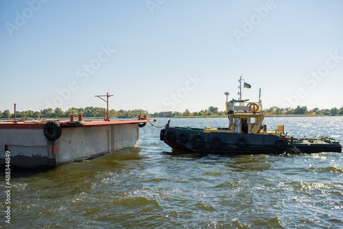 A tugboat pulls a floating concrete pontoon. © Ivan
