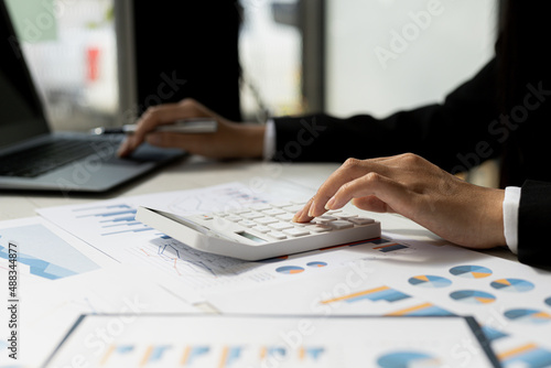 Wallpaper Mural Business women using a calculator to calculate numbers on a company's financial documents, he is analyzing historical financial data to plan how to grow the company. Financial concept. Torontodigital.ca