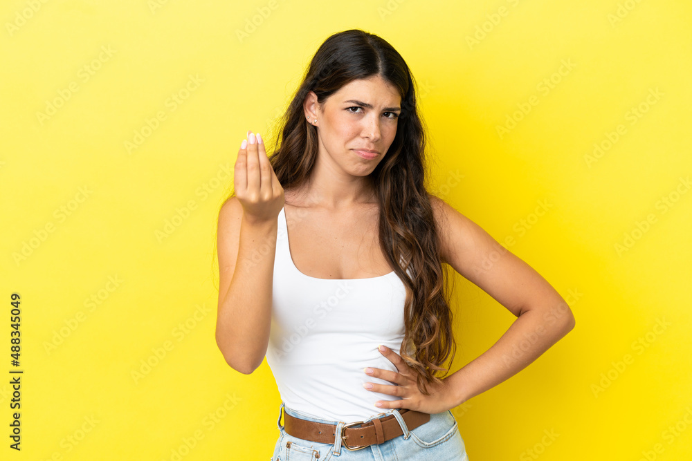 Young caucasian woman isolated on yellow background making Italian gesture Young caucasian woman isolated on yellow background making Italian gesture