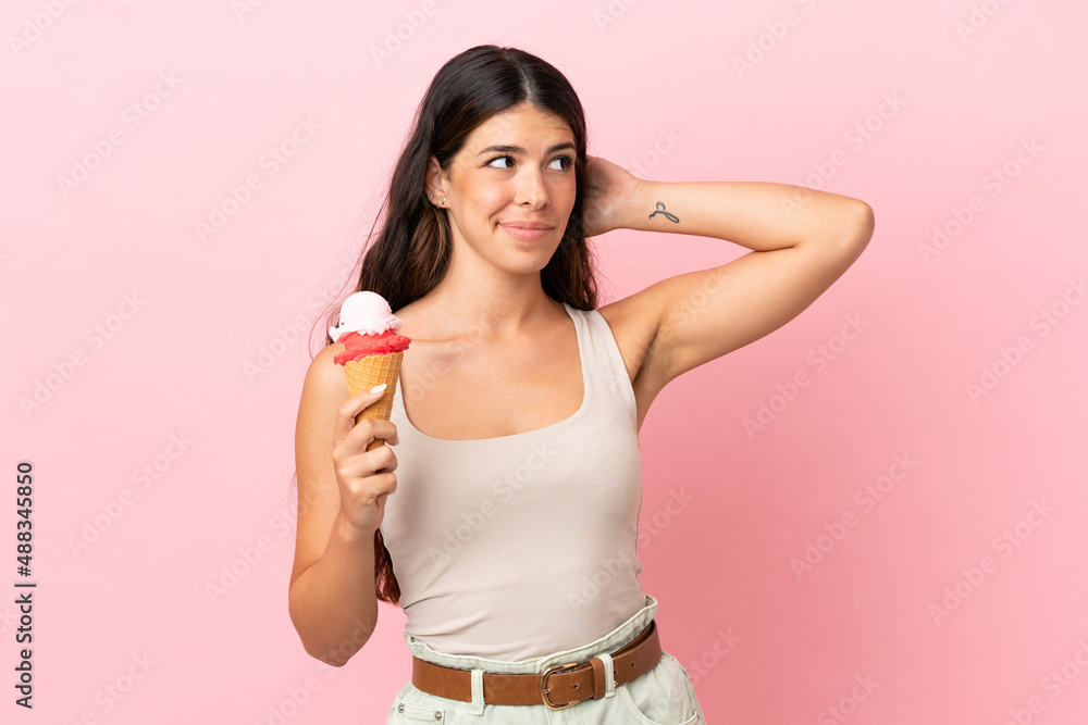Young caucasian woman with a cornet ice cream isolated on pink background having doubts Young caucasian woman with a cornet ice cream isolated on pink background having doubts