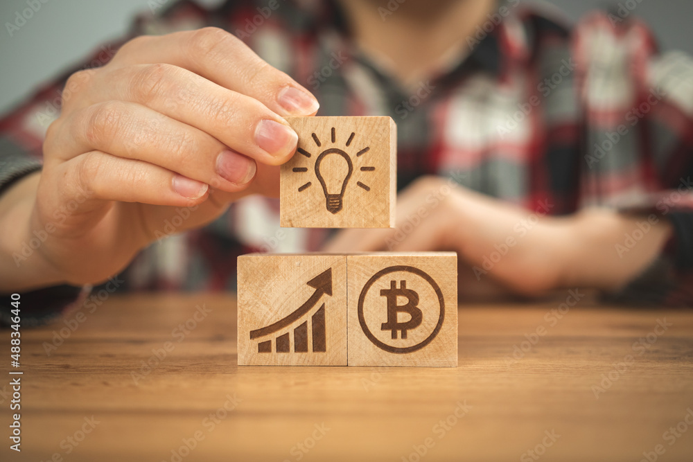 Concept of bitcoin growth. BTC graph of the growth symbols on a wooden cubes in hands close-up view. Business investment idea Concept of bitcoin growth. BTC graph of the growth symbols on a wooden cubes in hands close-up view. Business investment idea