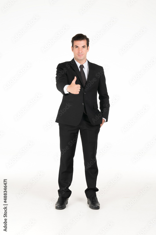 Portrait of a smiling western business man wearing a black suit with thumbs up and his hands in his pants pocket at studio shot on white background. Portrait of a smiling western business man wearing a black suit with thumbs up and his hands in his pants pocket at studio shot on white background.