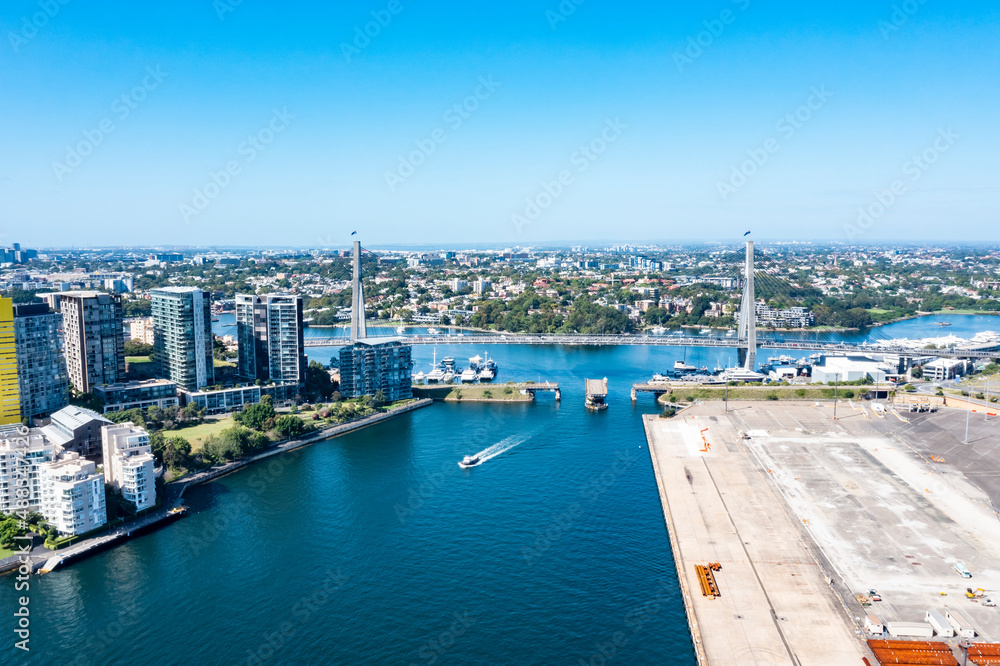 Aerial drone view of Anzac Bridge across Johnstons Bay looking toward Rozelle Bay and Bicentennial Park in Rozelle, Sydney, Australia on a sunny morning   
