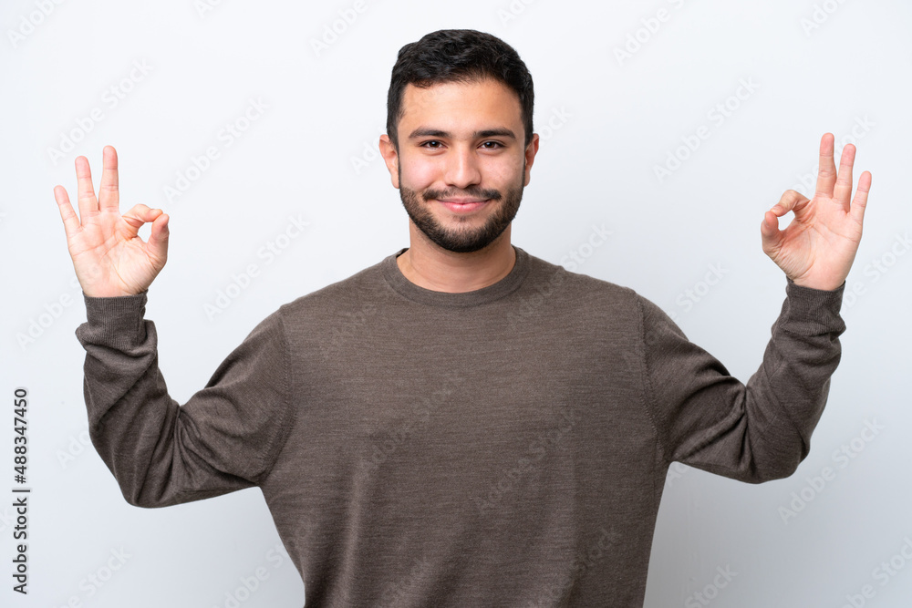 Naklejka premium Young Brazilian man isolated on white background in zen pose