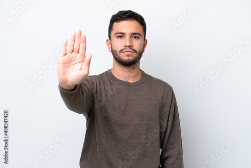 Young Brazilian man isolated on white background making stop gesture